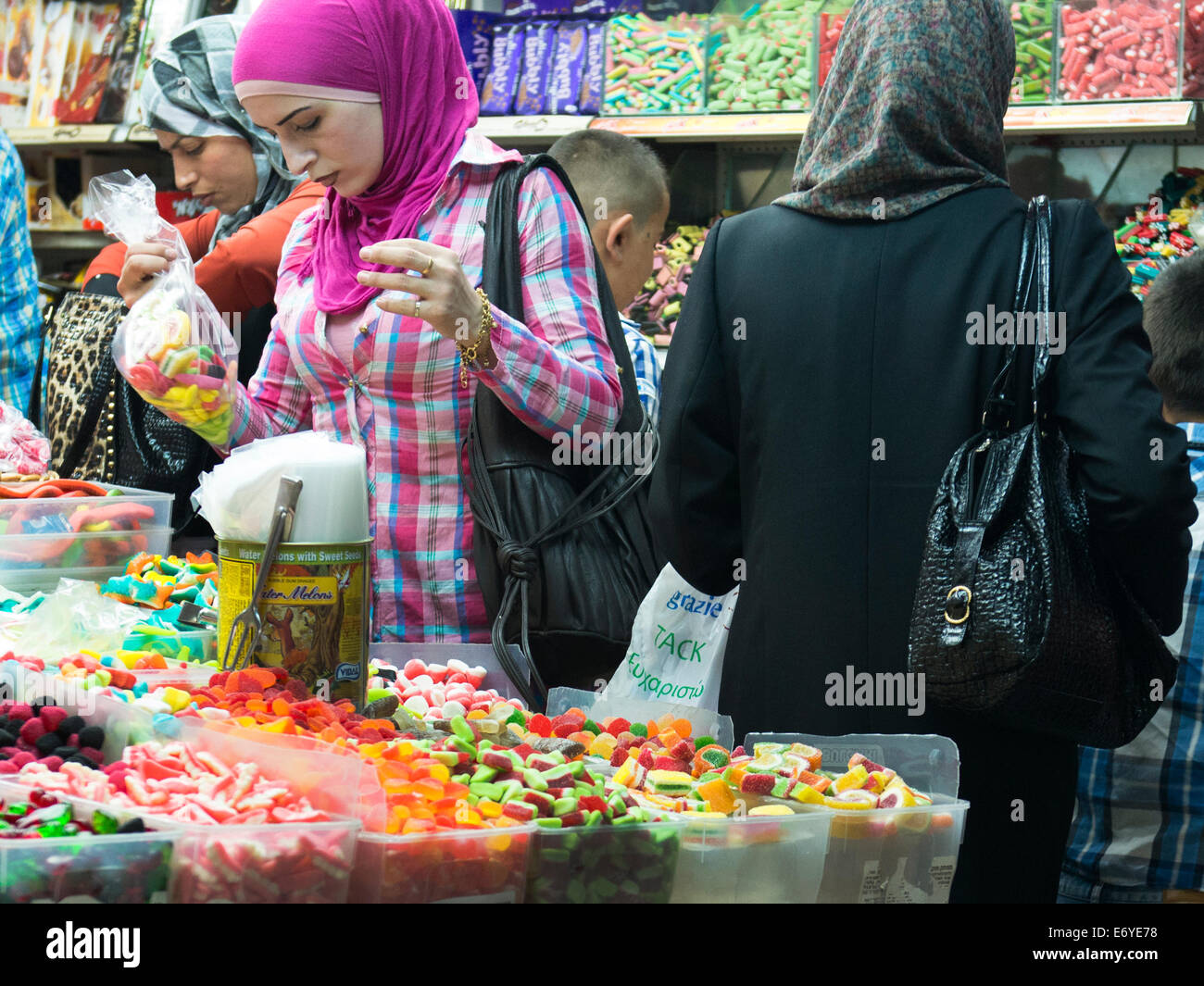 Palestinian women in a busy candy shop in the vibrant old city bazaar. Stock Photo