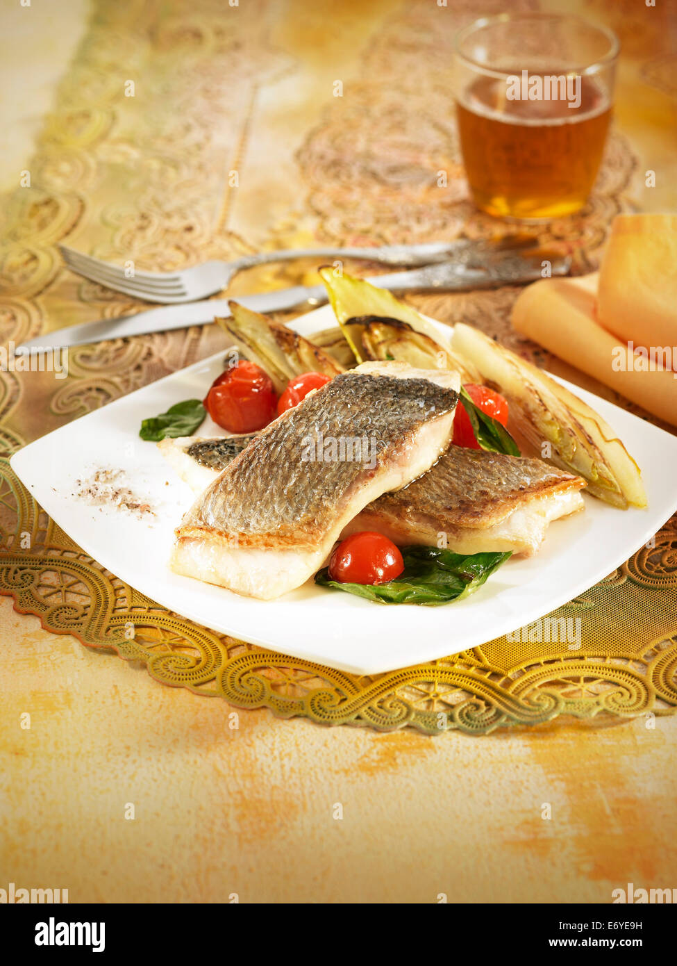 Grilled sea bream fillets with chicory,spinach and cherry tomatoes Stock Photo