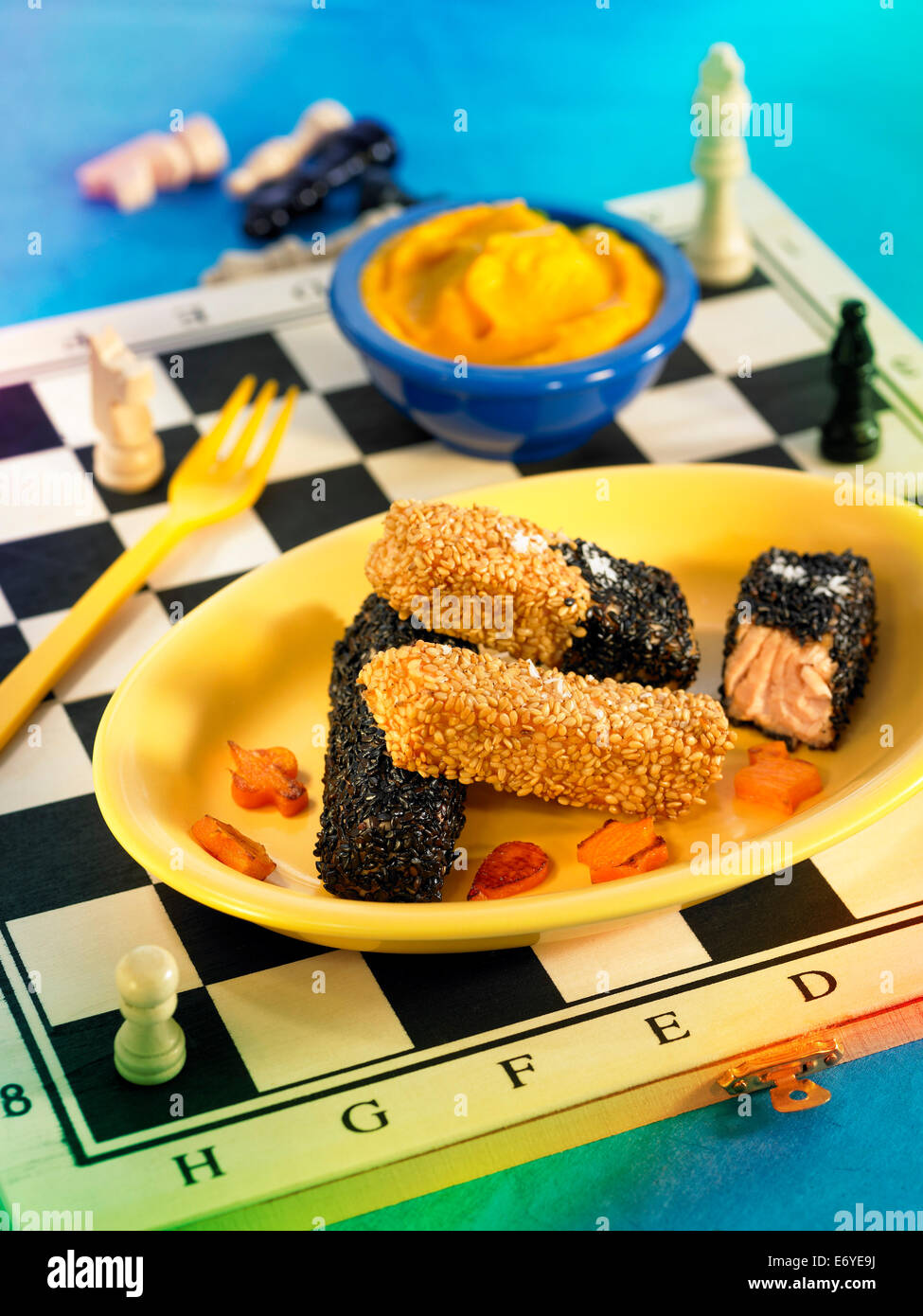 Fish fingers coated in black and golden sesame seeds Stock Photo