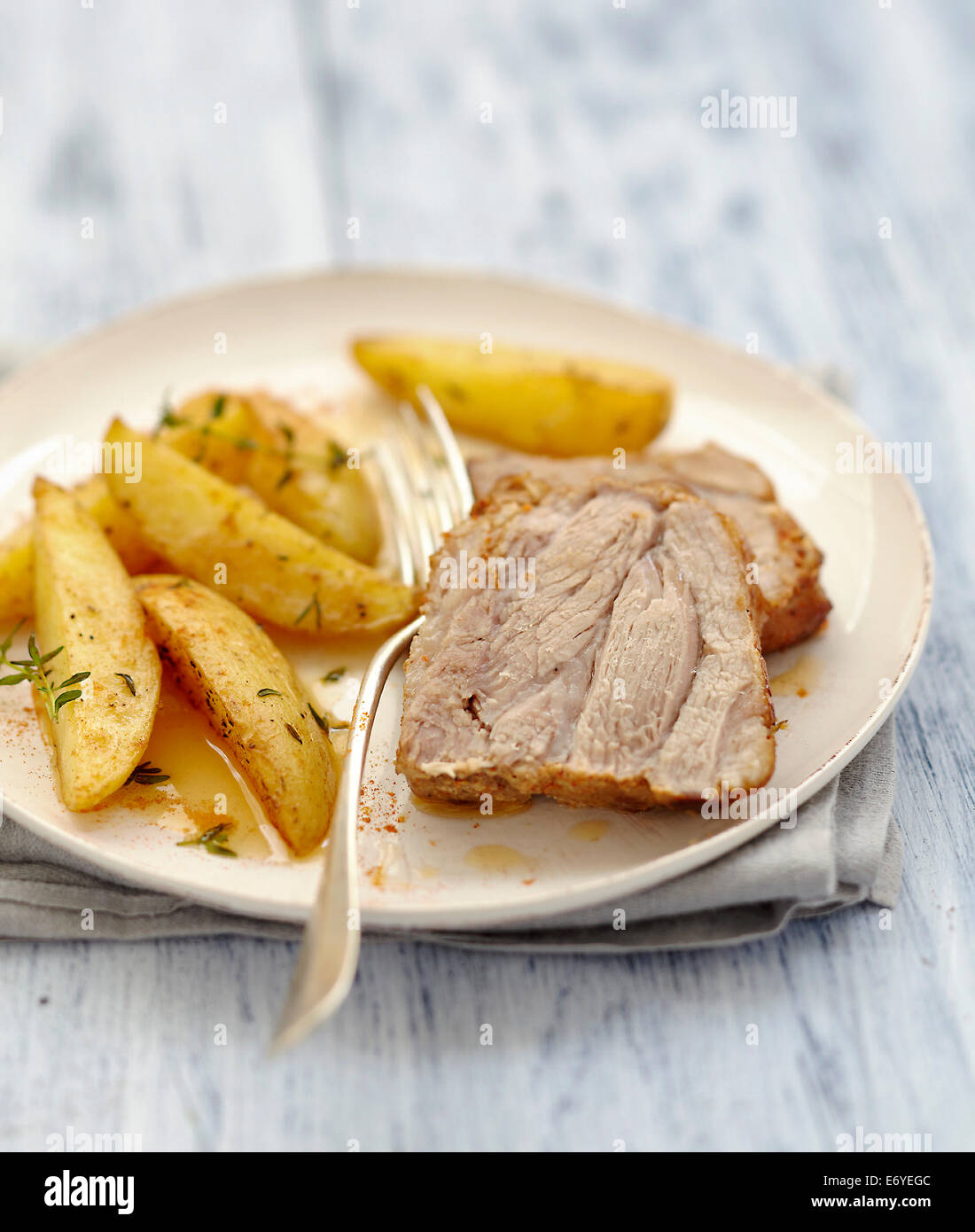 Roast pork marinated in spices,fried potatoes with thyme Stock Photo