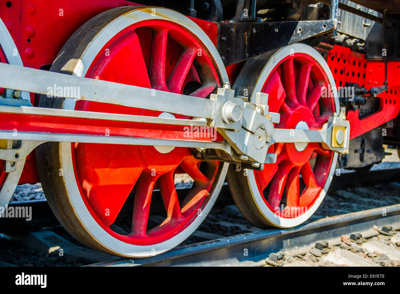 Closeup view of red wheels and driving rods of an ancient steam train Stock Photo