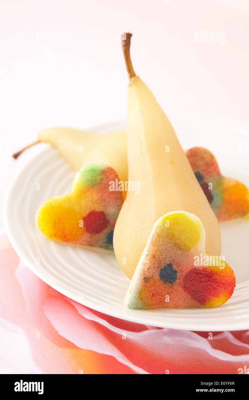 Multicolored jelly fruit hearts with poached pears Stock Photo