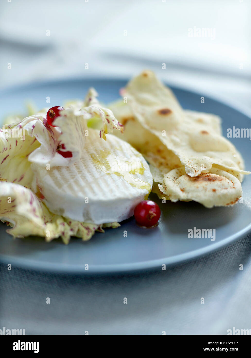Goat's cheese with redcurrants and spicy crisp bread Stock Photo