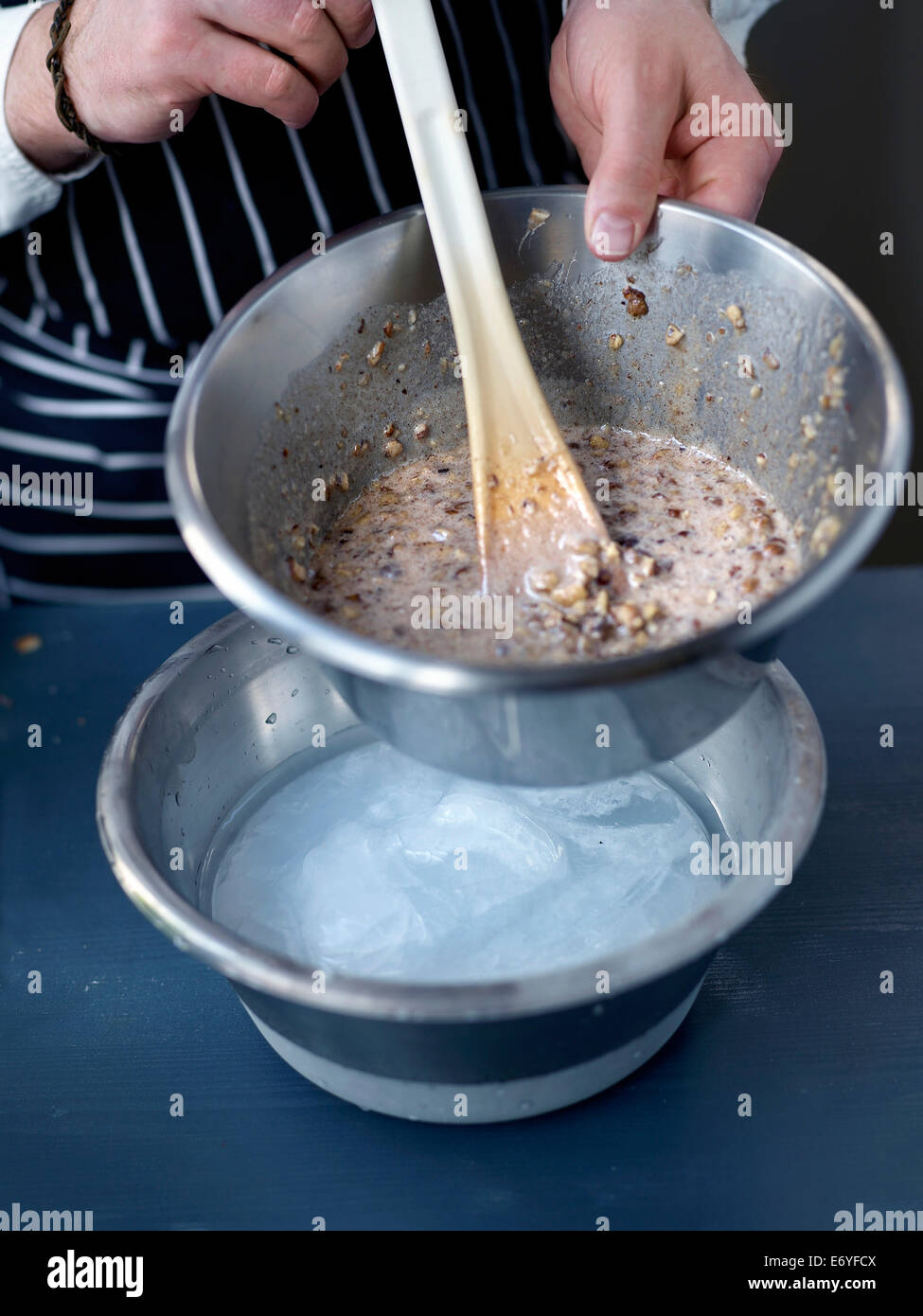 Placing the bowl of mixture in a bigger bowl full of freezing water Stock Photo