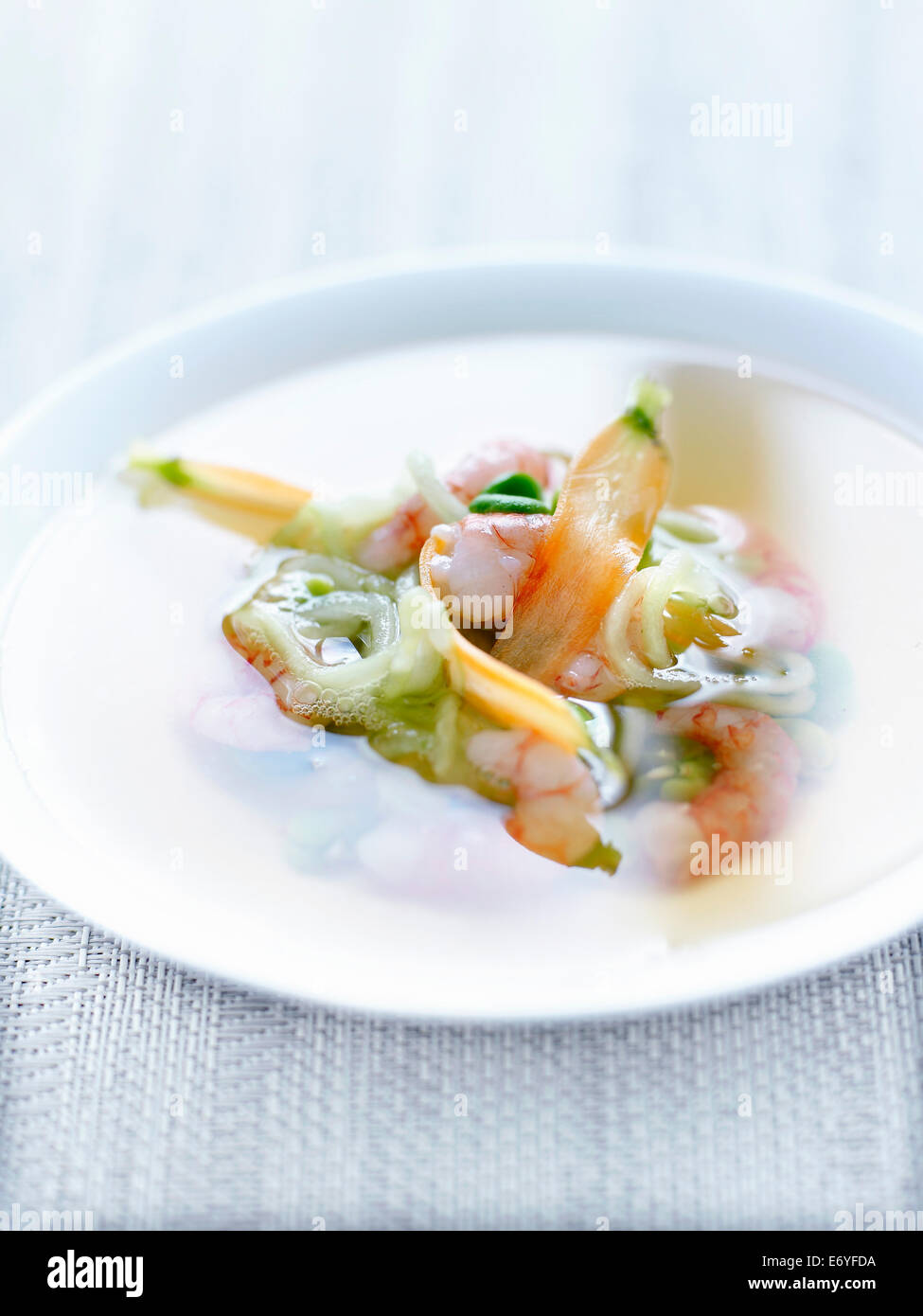 Tea broth with king prawns and spring vegetables Stock Photo