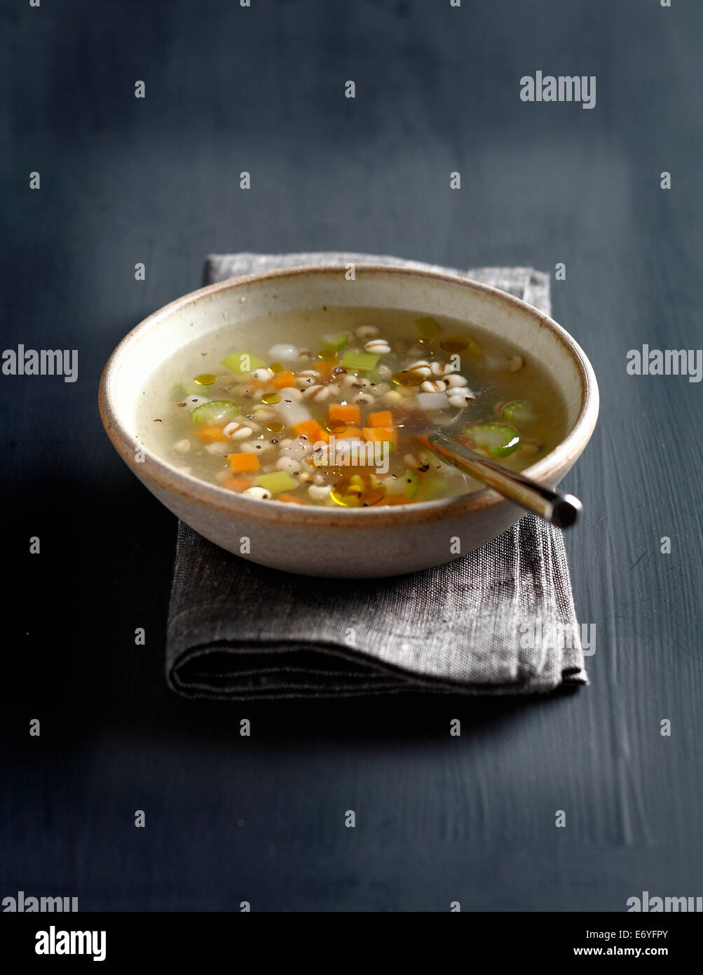 Vegetable broth with pearl barley and basil oil Stock Photo