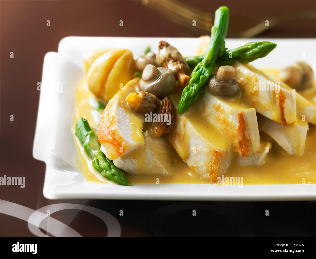 Capon with two types of mushrooms,chestnuts and asparagus,foie gras sauce Stock Photo
