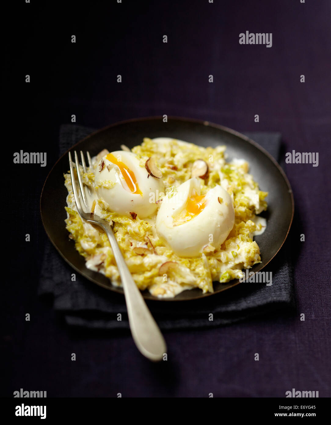 Braised green cabbage with hazelnuts and soft-boiled eggs Stock Photo