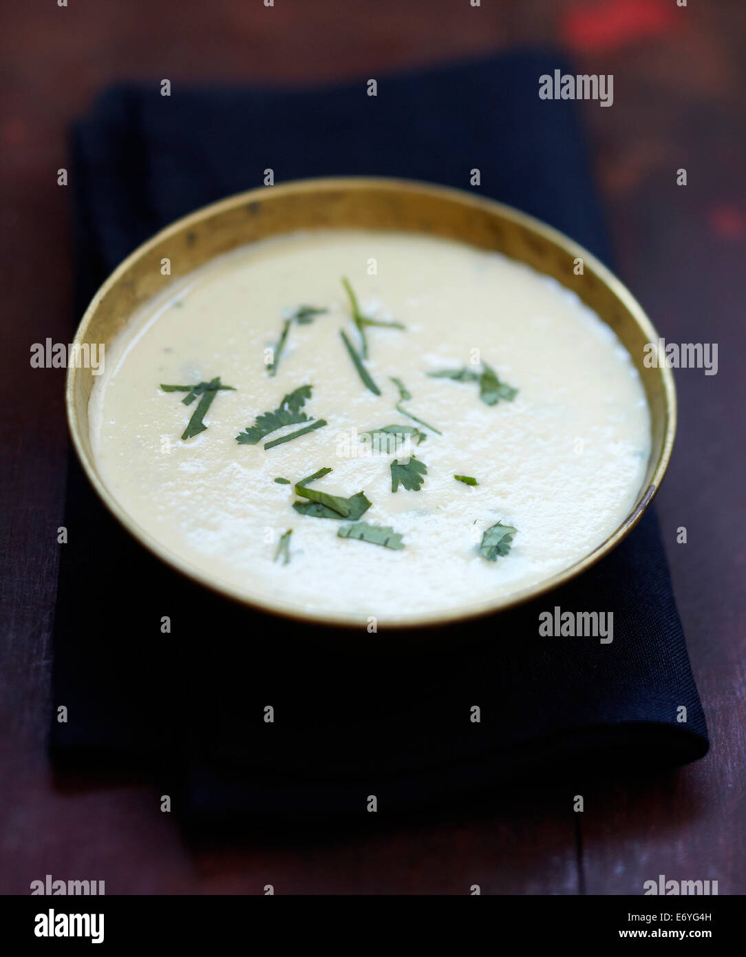 Cream of orange lentil and coconut milk soup with cilantro Stock Photo