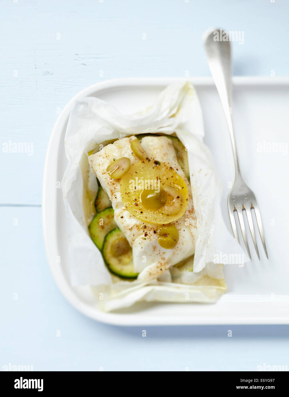 Cod with citrus confit and green olives cooked in wax paper Stock Photo