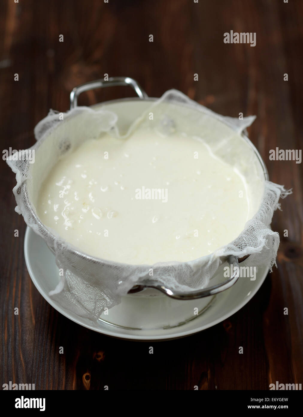 Draining the homemade lemon yoghurts through a mousseline cloth Stock Photo