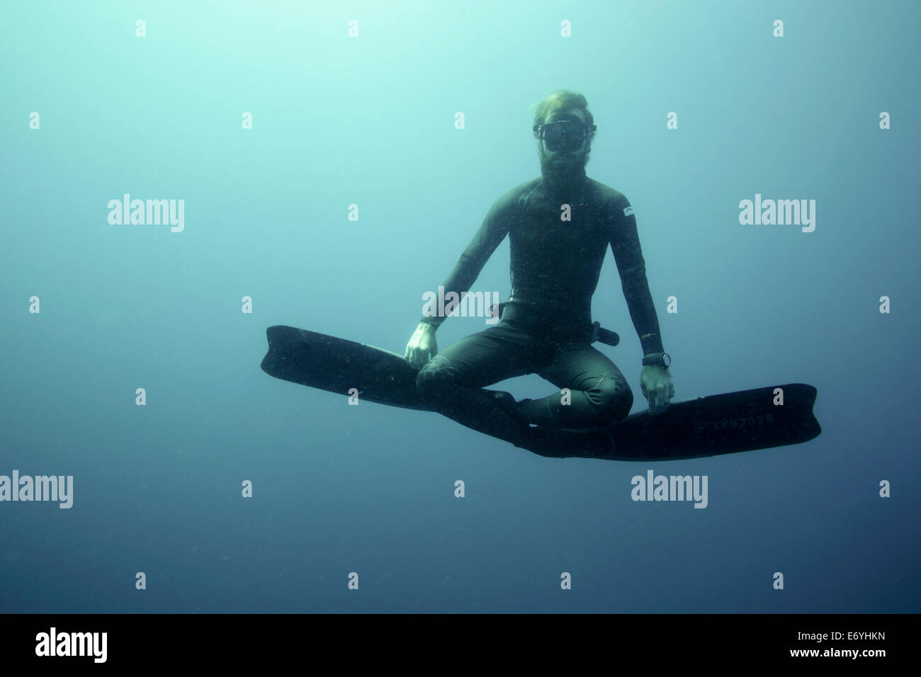 Free diver sitting in lotus position underwater Stock Photo