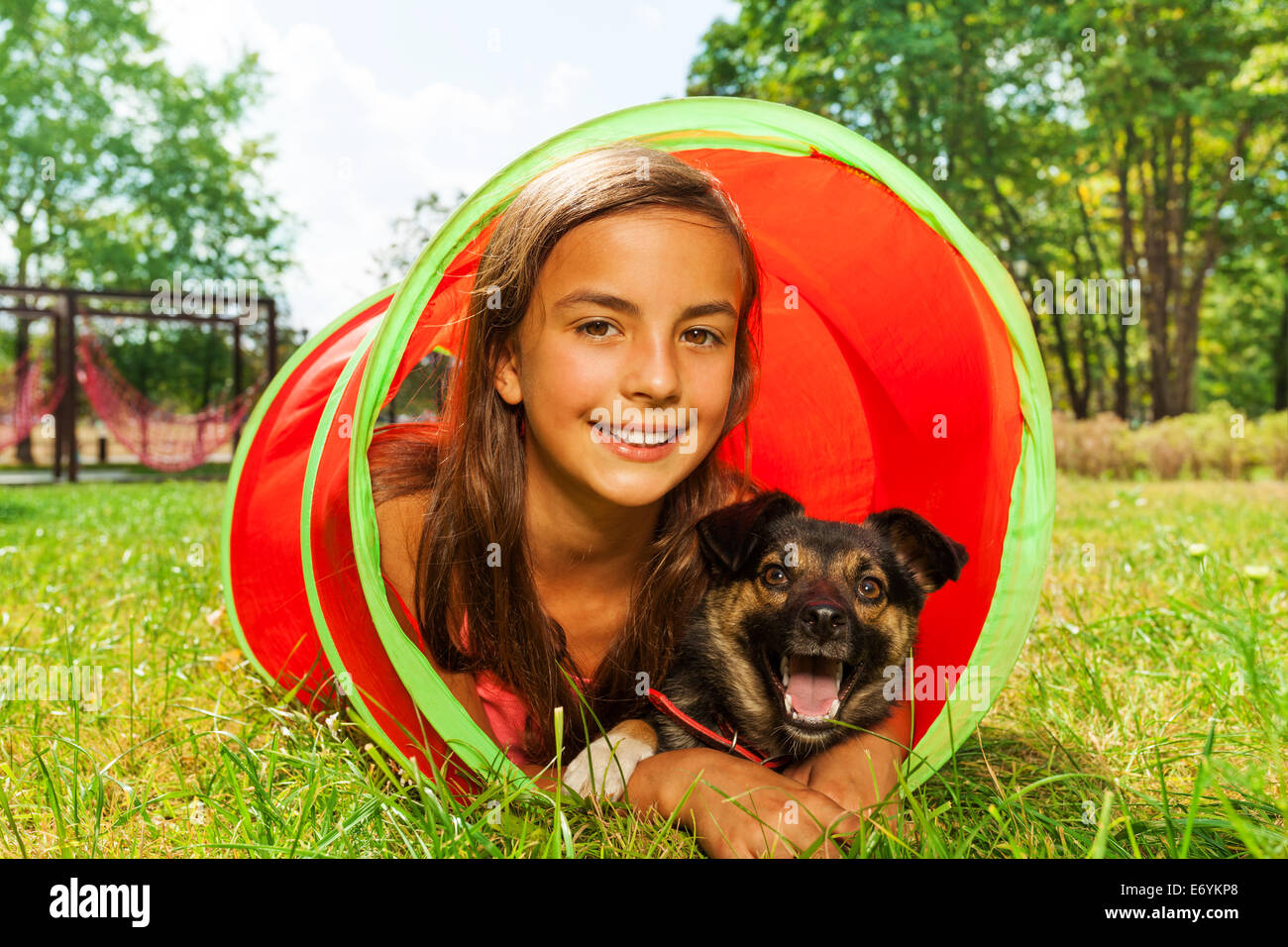 Girl with dog play in playground tube Stock Photo