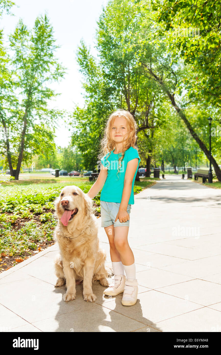 Little curly blond girl with dog in sunny park Stock Photo - Alamy