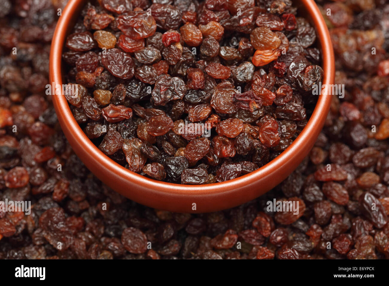 Raisins in bowl on raisins background. Closeup. Stock Photo