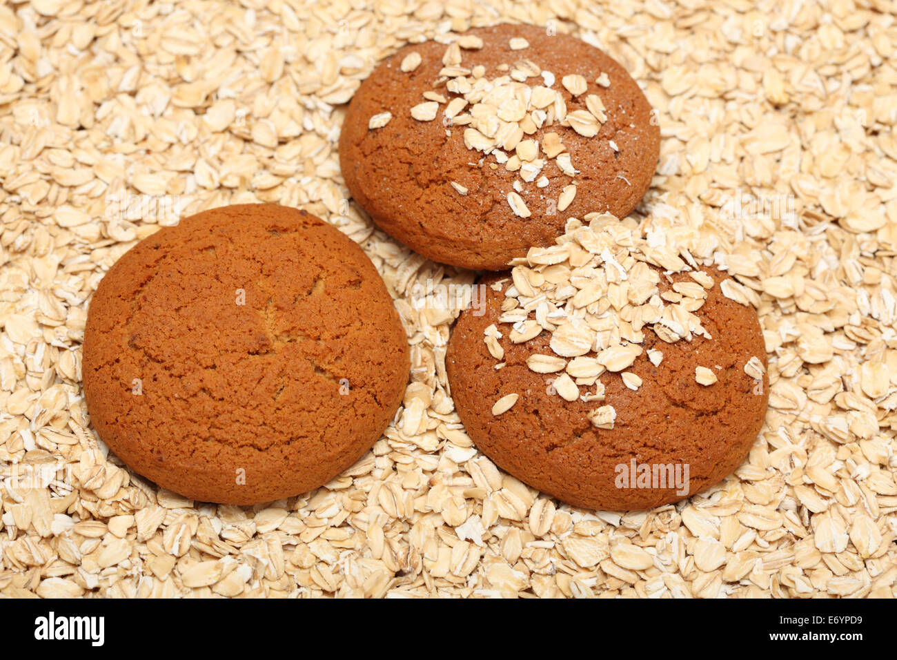 Oatcakes on rolled oats background. Closeup. Stock Photo