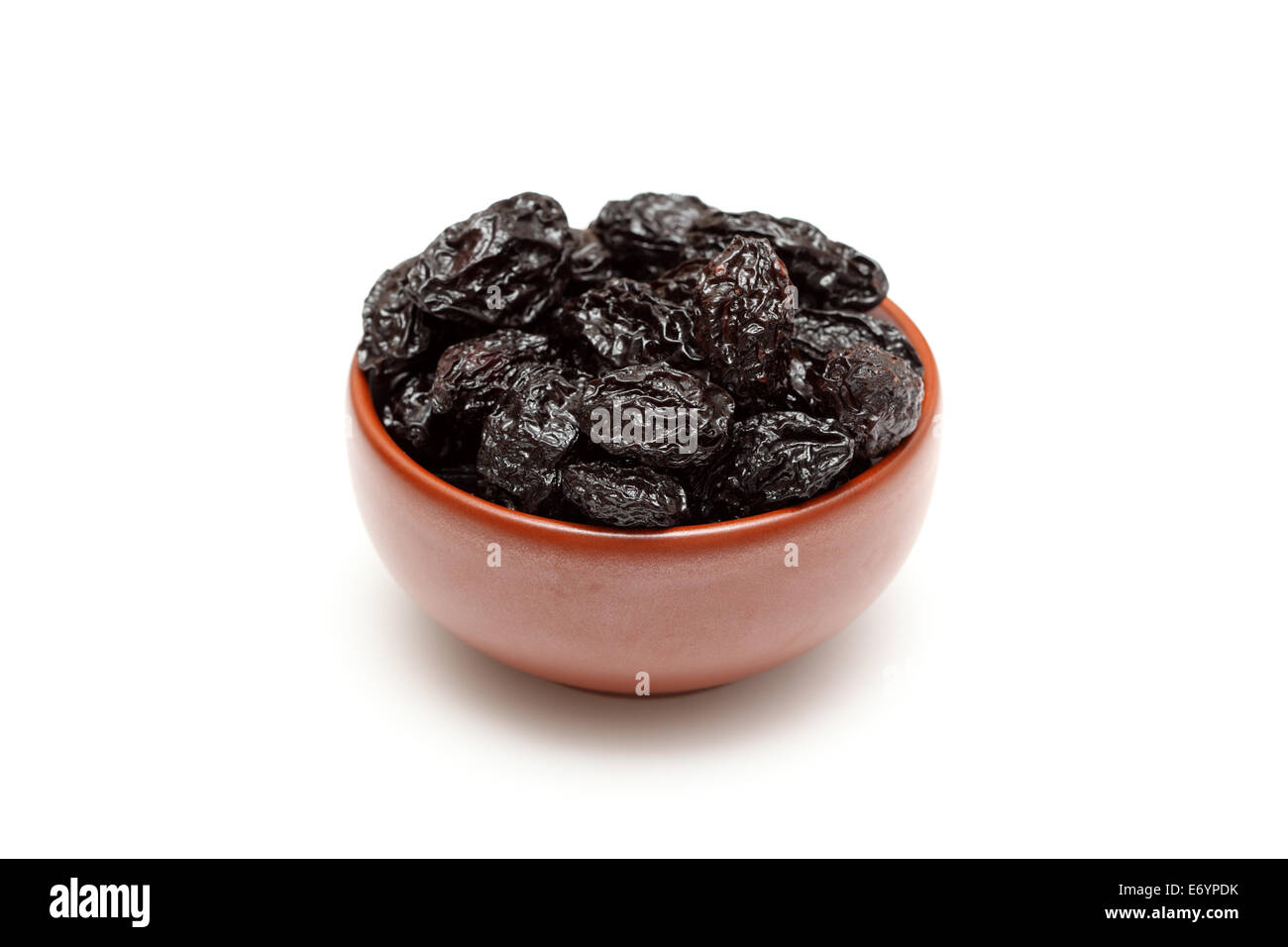 Dried prunes in bowl on white background. Closeup Stock Photo Alamy