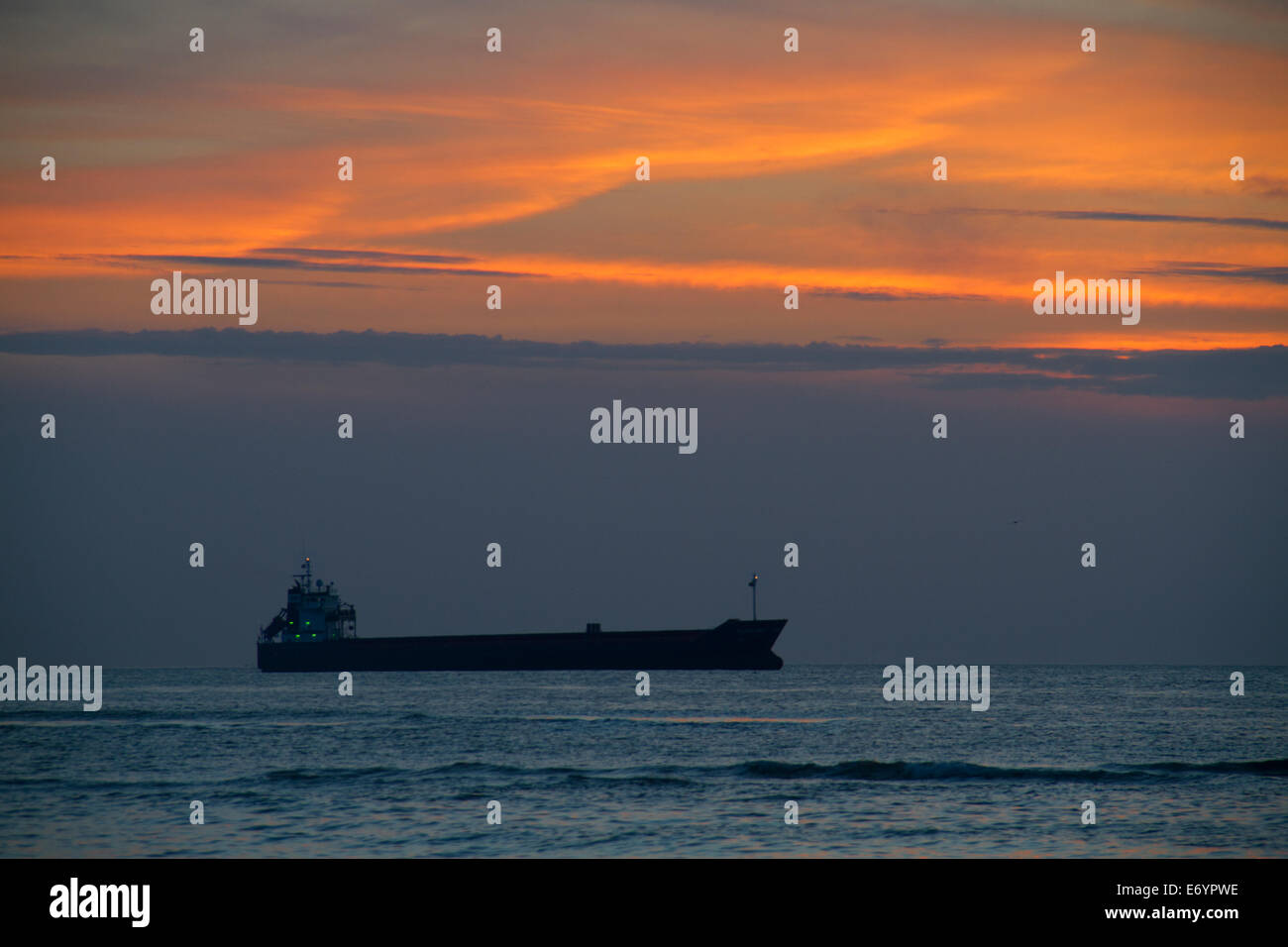 Ship on a dark sea at sunset Stock Photo