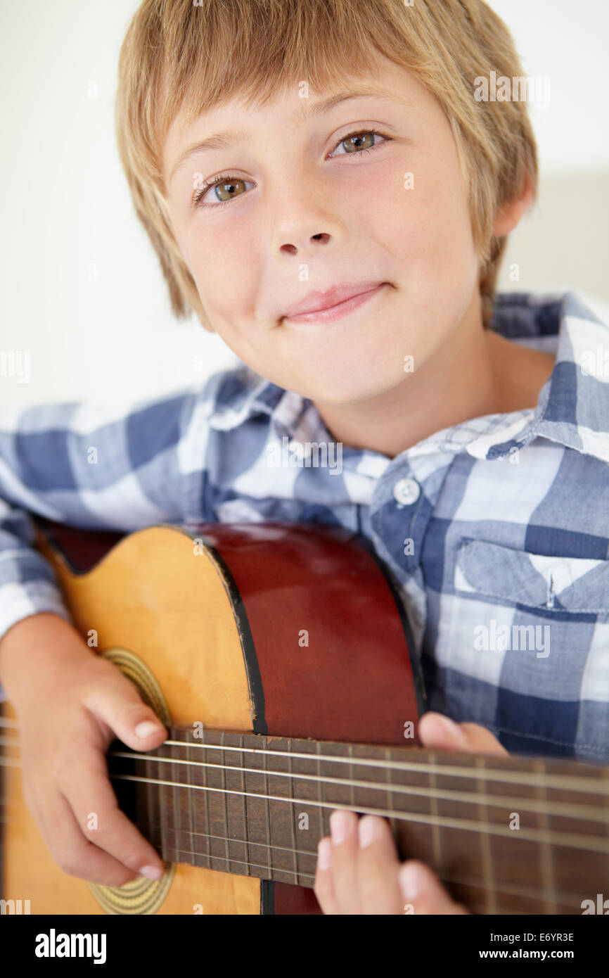 Young boy playing acoustic guitar Stock Photo