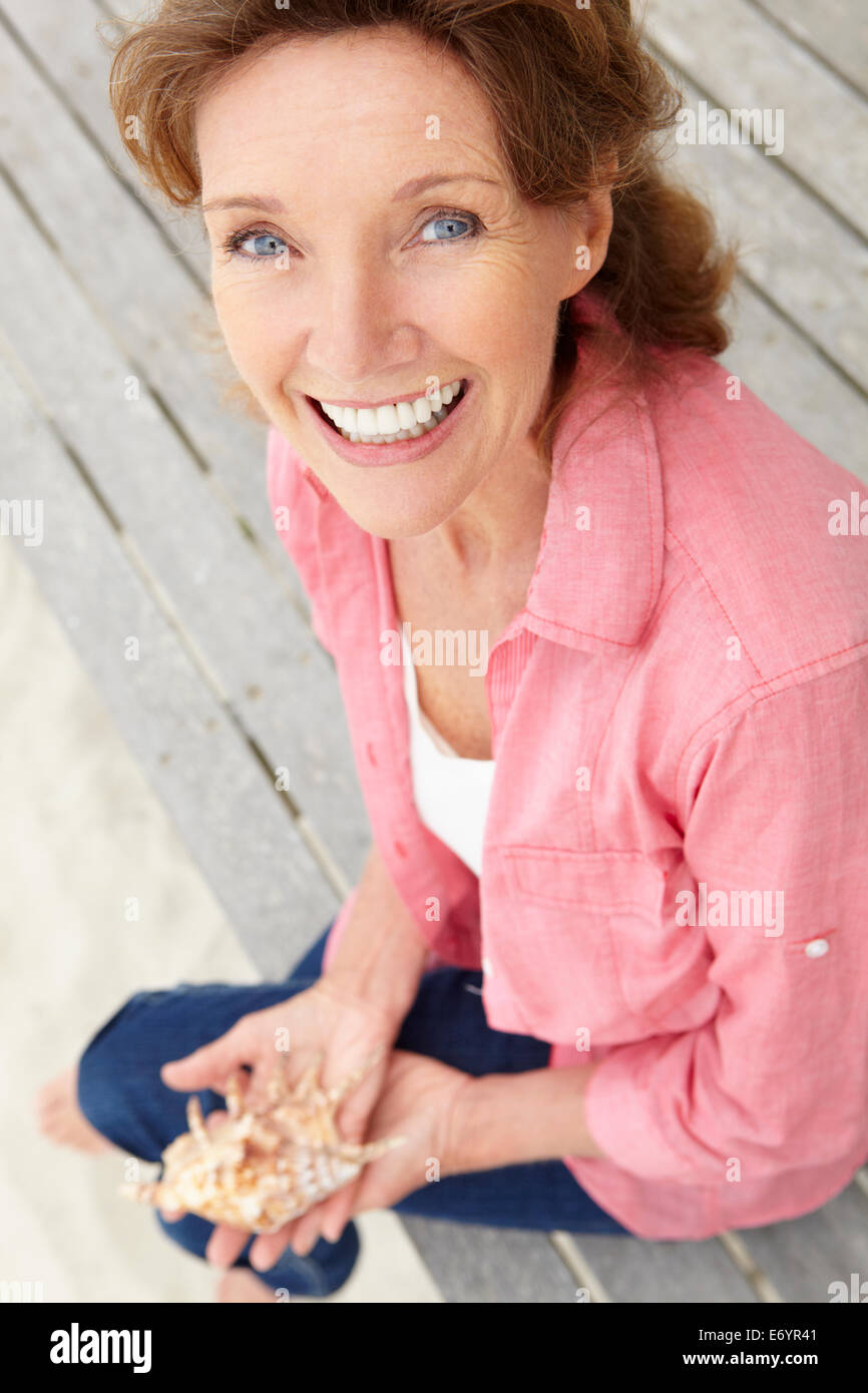 Senior woman holding seashell Stock Photo