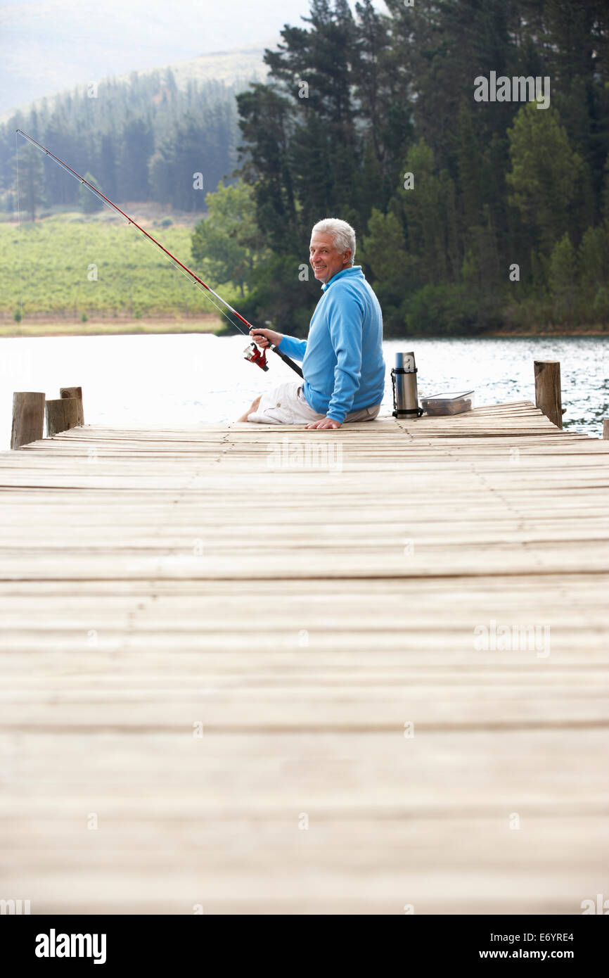 Senior man fishing on jetty Stock Photo