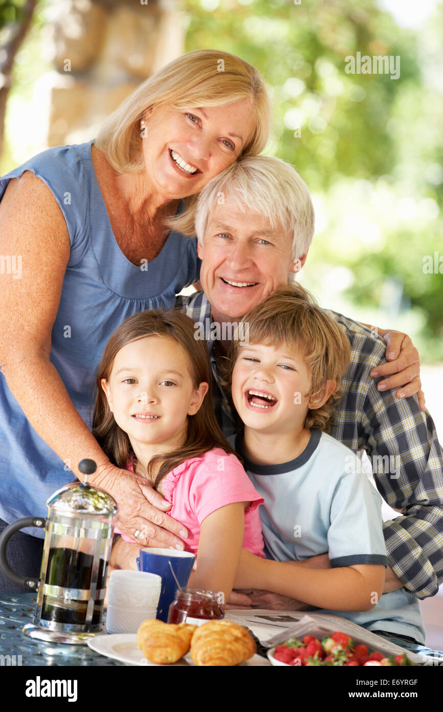 Senior couple and grandchildren eating breakfast outdoors Stock Photo