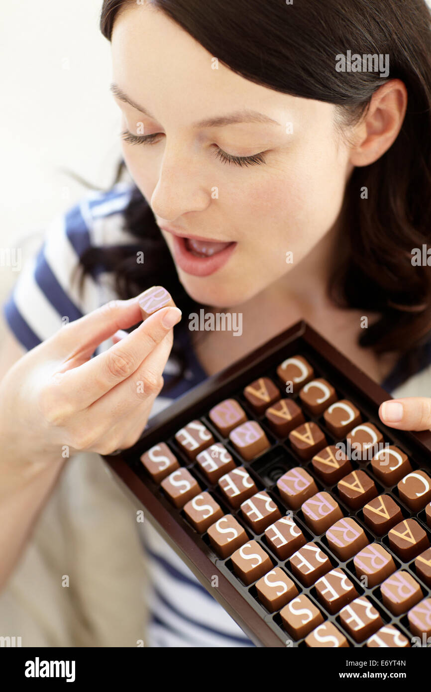 Woman eating chocolates Stock Photo Alamy
