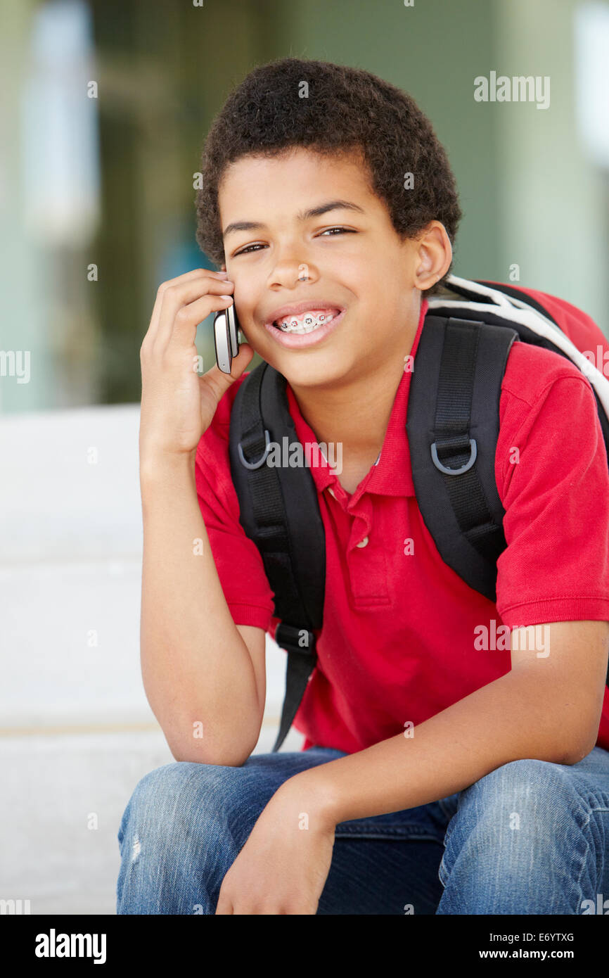 Pre teen boy with phone at school Stock Photo