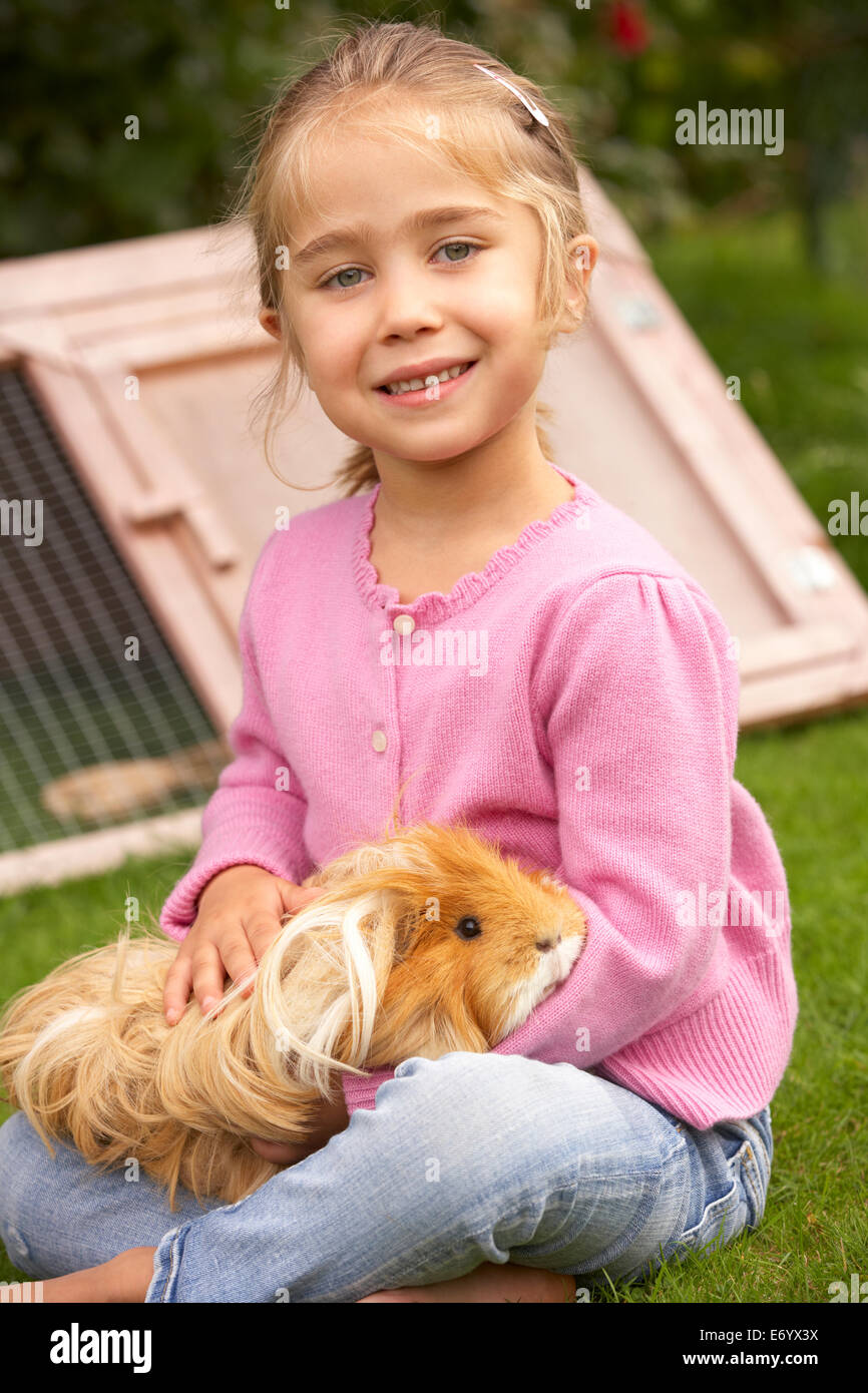 Young girl in garden holding guinea pig Stock Photo