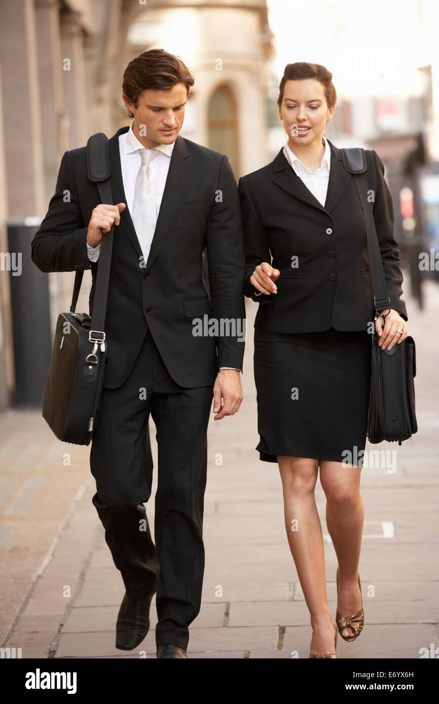 Businessman and businesswoman walking in street Stock Photo - Alamy