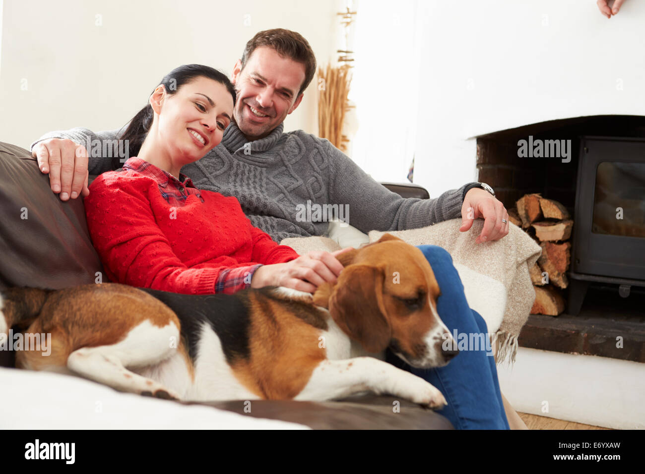 Couple Relaxing At Home With Pet Dog Stock Photo