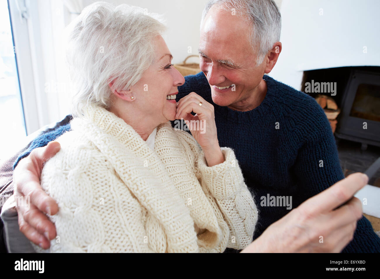 Senior Couple Sitting On Sofa And Relaxing Stock Photo