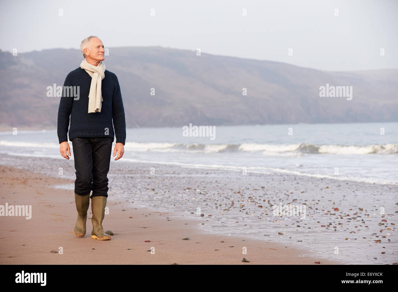 Senior Man Walking Along Winter Beach Stock Photo - Alamy