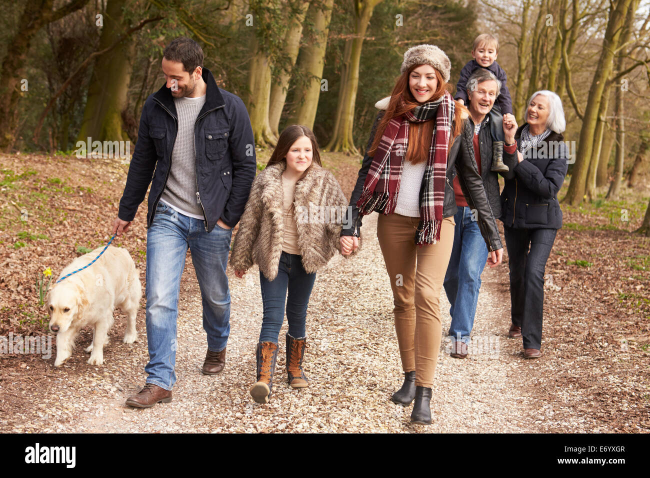 Couple Taking Dog For Walk On City Street Stock Photo