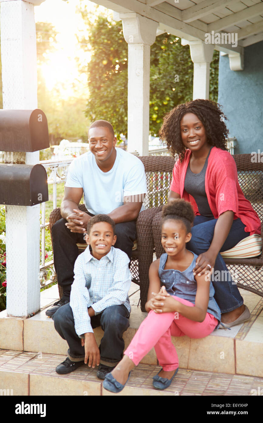 Portrait Of Family Sitting Outside House Stock Photo
