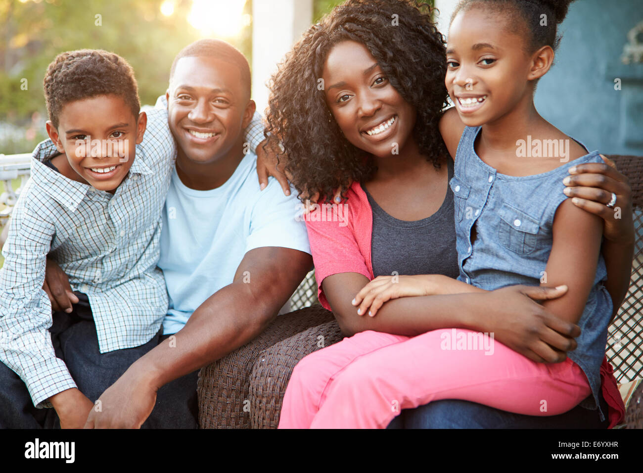 Portrait Of Family Sitting Outside House Stock Photo