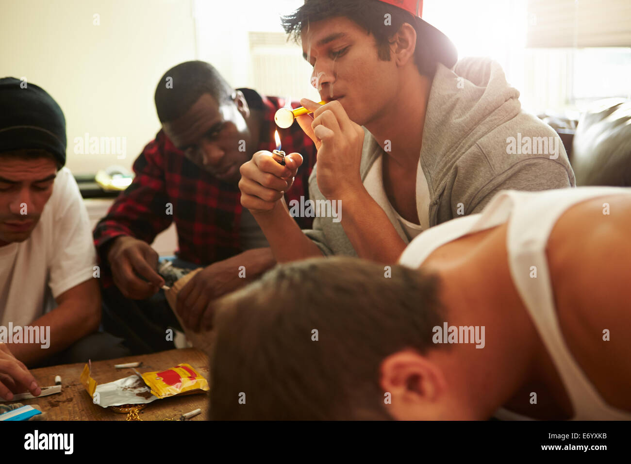 Gang Of Young Men Taking Drugs Indoors Stock Photo
