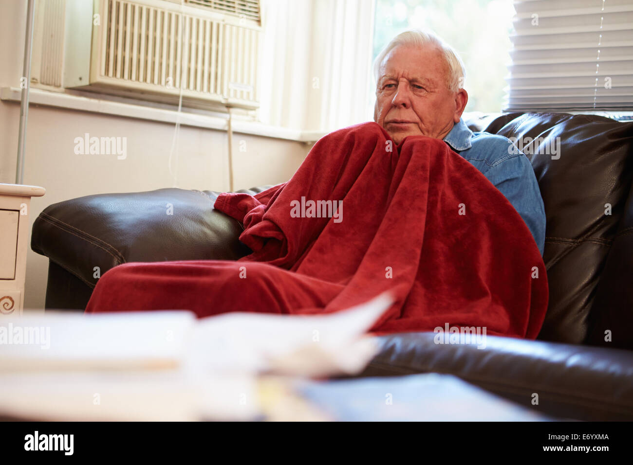 Senior Man Trying To Keep Warm Under Blanket At Home Stock Photo Alamy