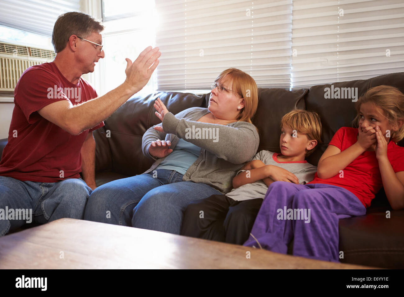 Physically Abusive Father With Family On Sofa Stock Photo