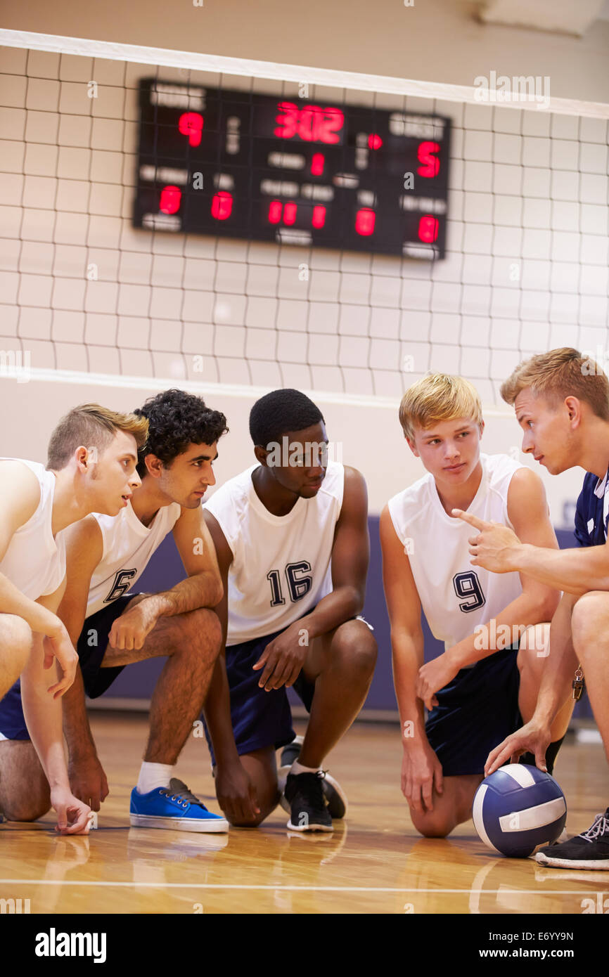 Male High School Volleyball Team Having Team Talk From Coach Stock