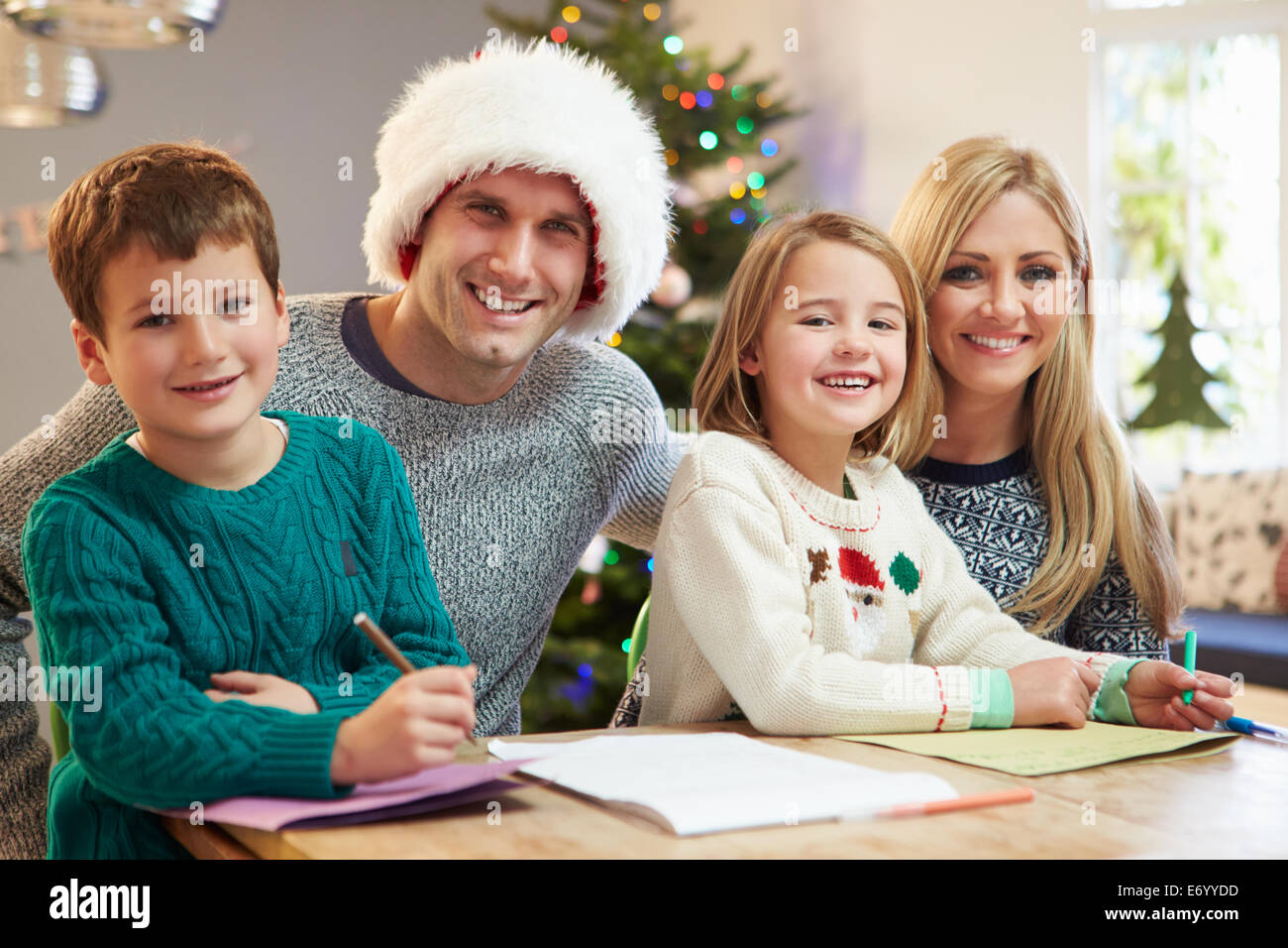 Family Writing Christmas Cards Together Stock Photo