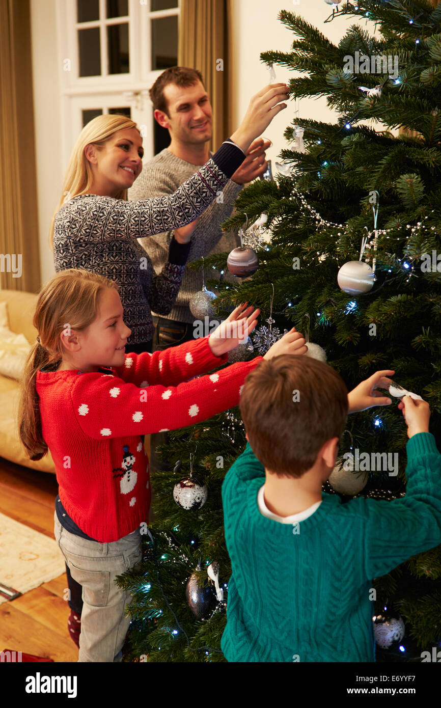 Family Decorating Christmas Tree At Home Together Stock Photo