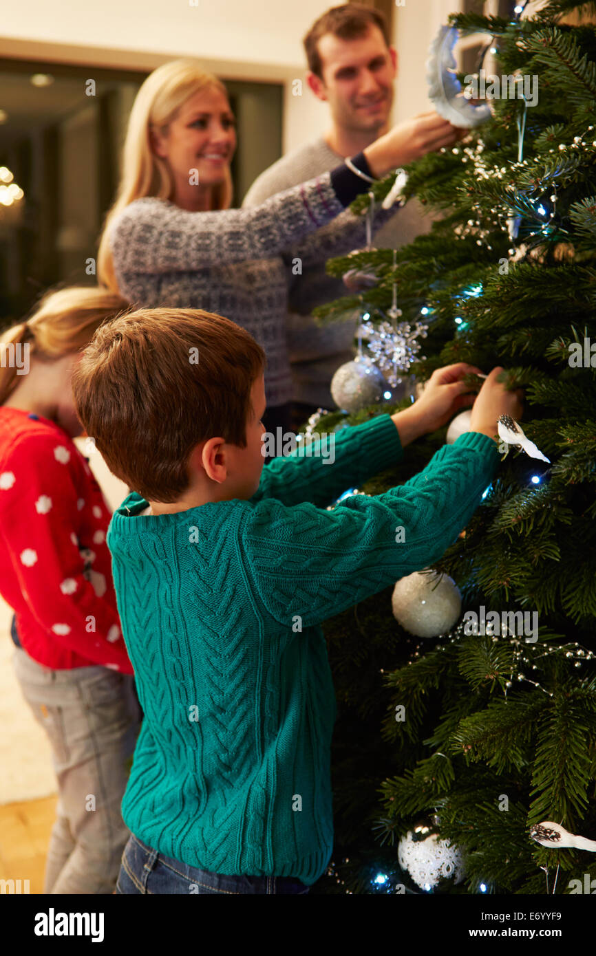 Family Decorating Christmas Tree At Home Together Stock Photo
