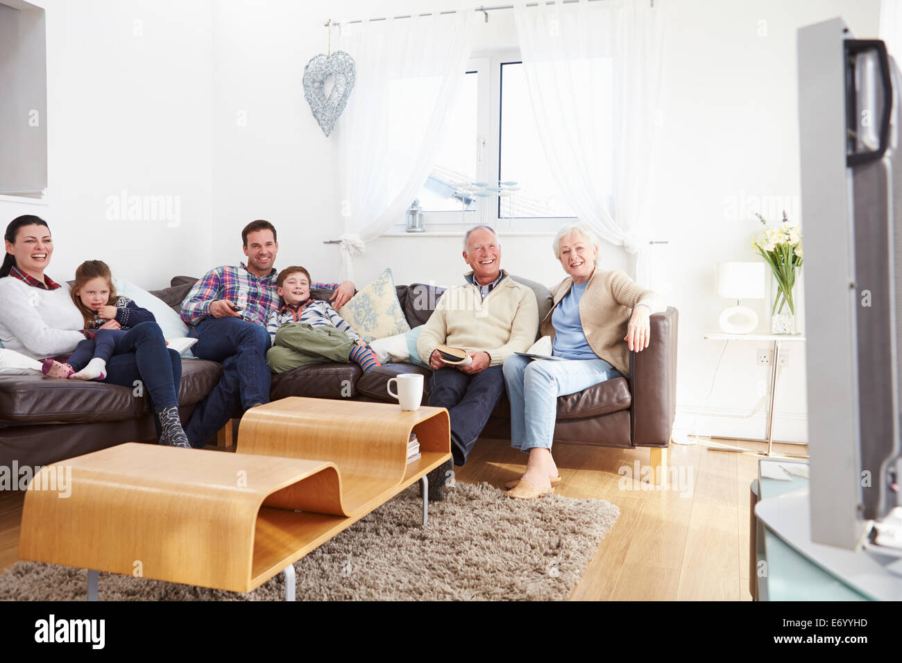 Multi Generation Family Watching TV Together Stock Photo