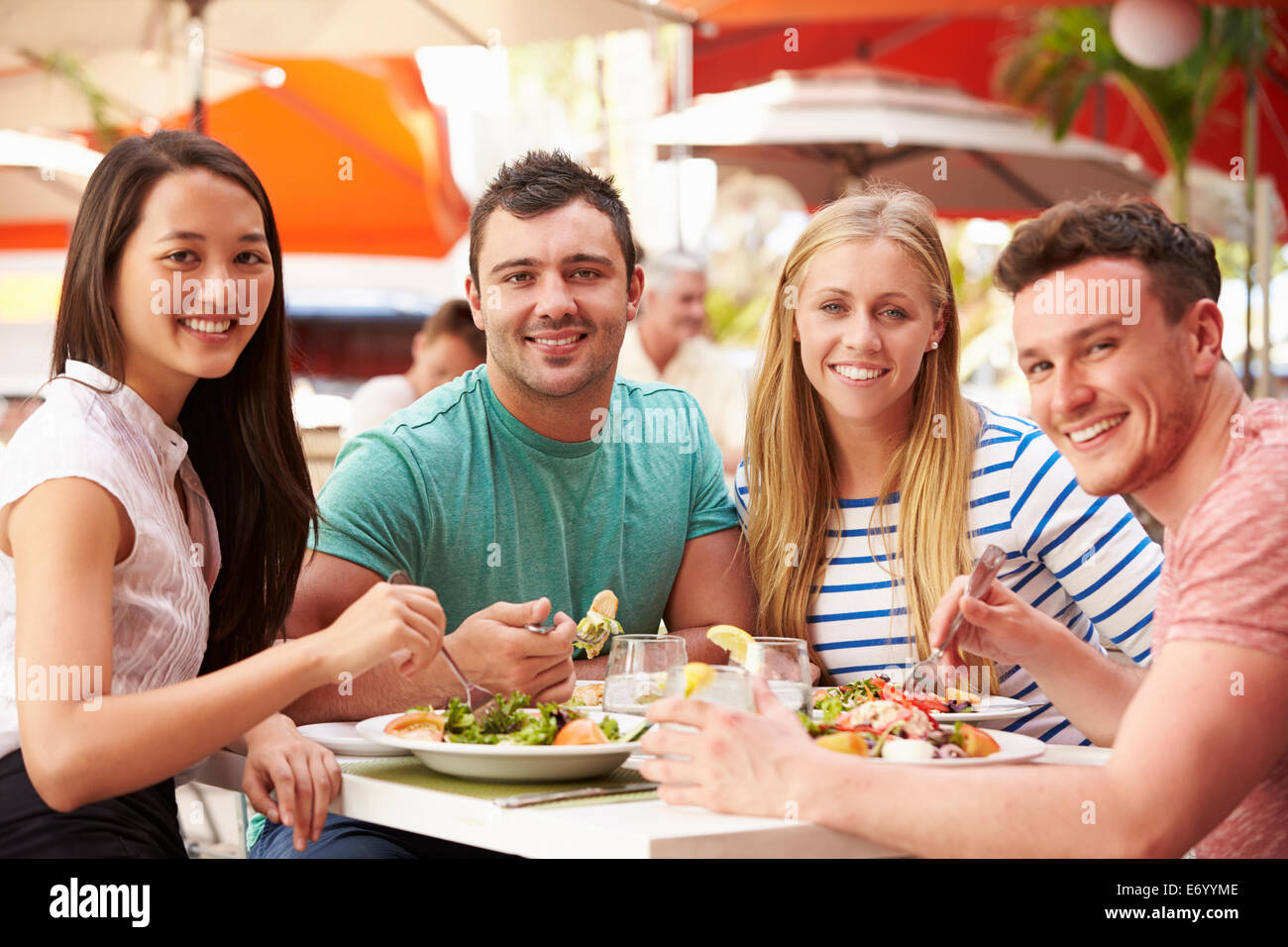 Group Of Friends Enjoying Lunch In Outdoor Restaurant Stock Photo