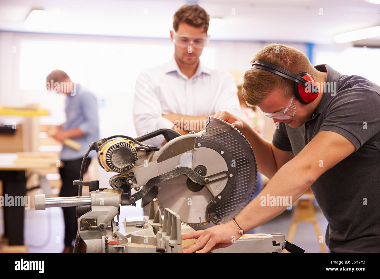 Student And Teacher In Carpentry Class Using Circular Saw Stock Photo