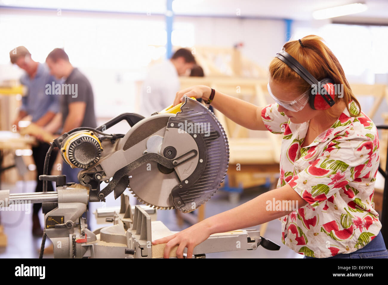 Female Student In Carpentry Class Using Circular Saw Stock Photo