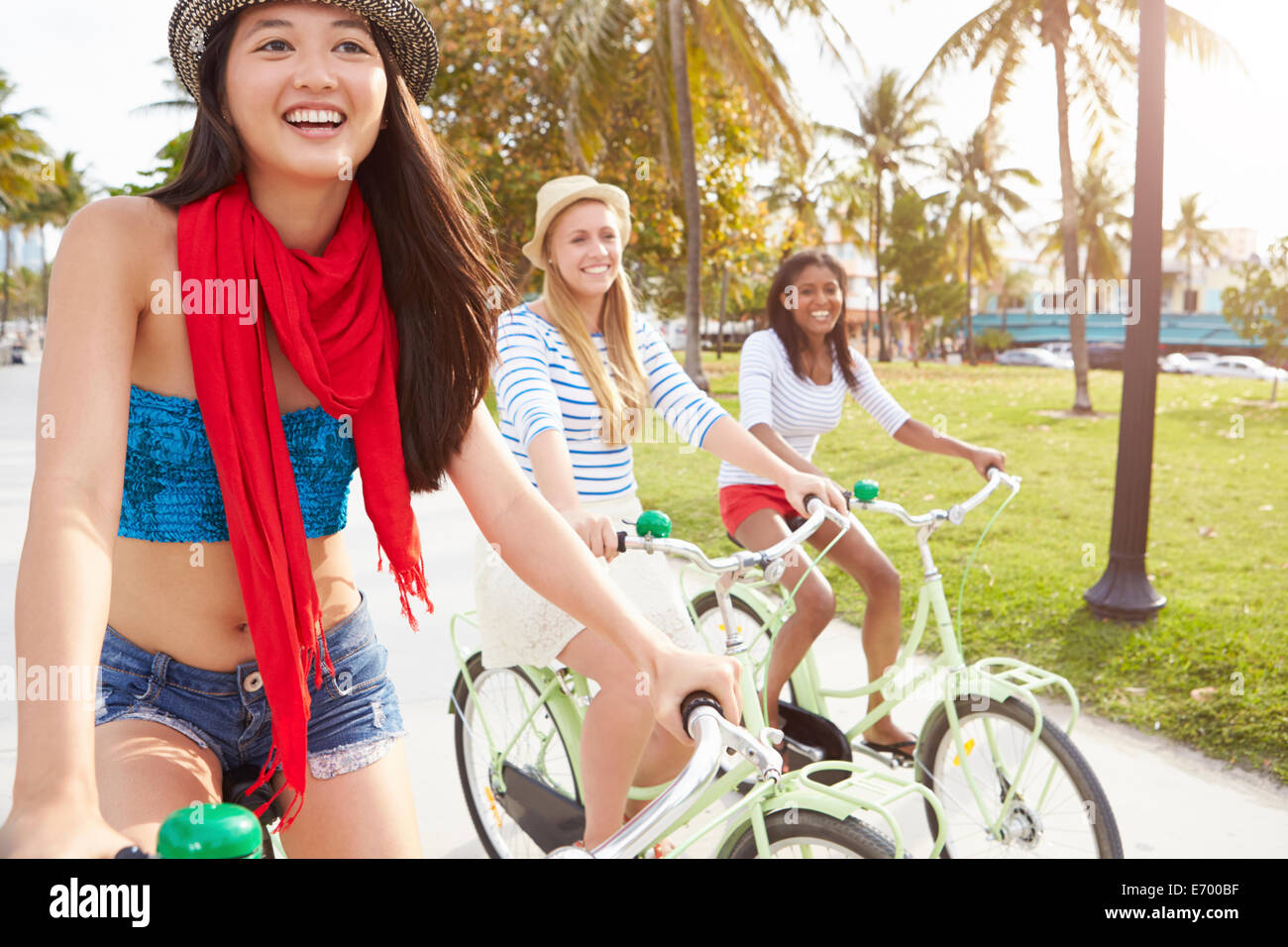 Female Friends Having Fun On Bicycle Ride Stock Photo