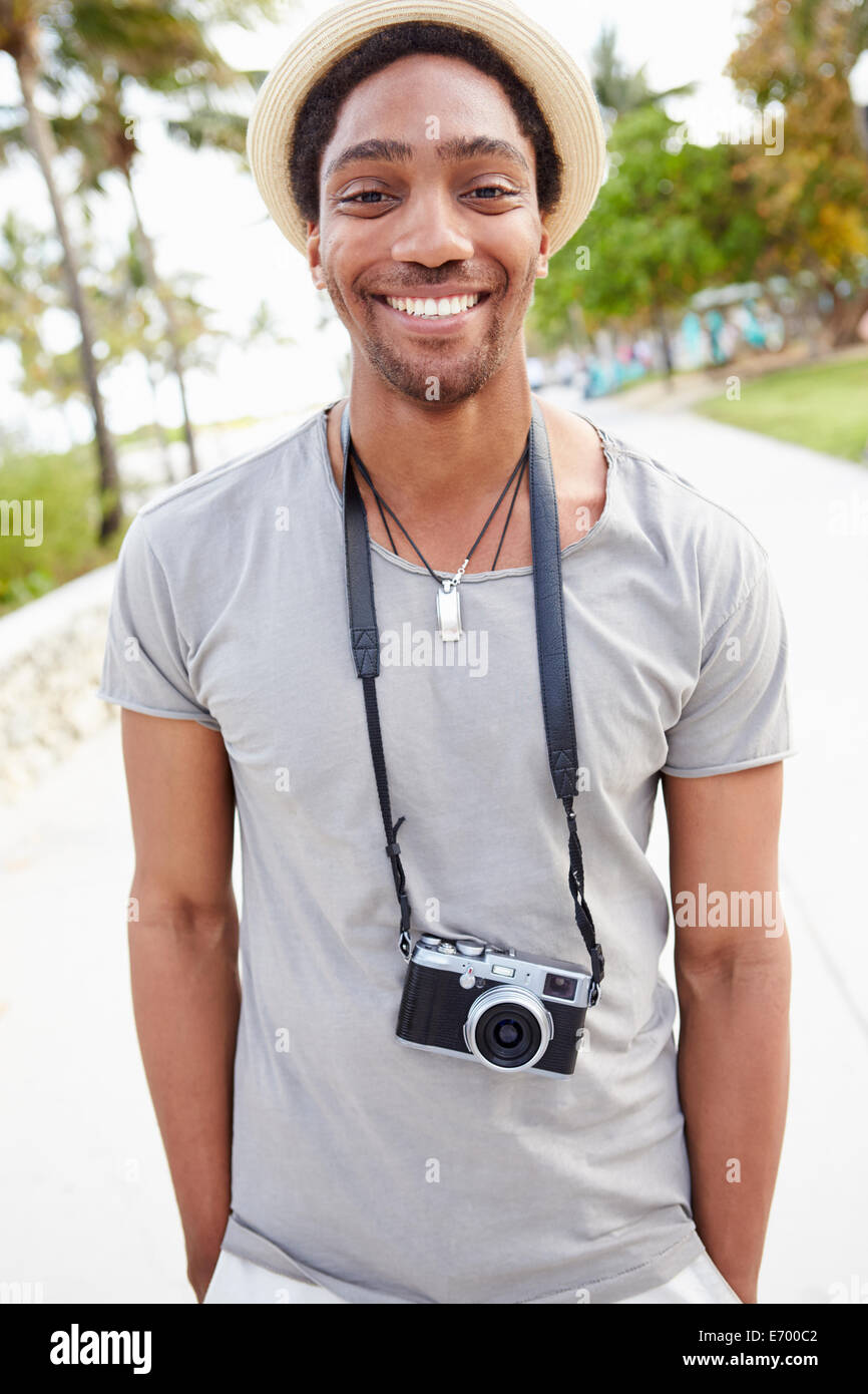 Portrait Of Young Man Carrying Camera Stock Photo