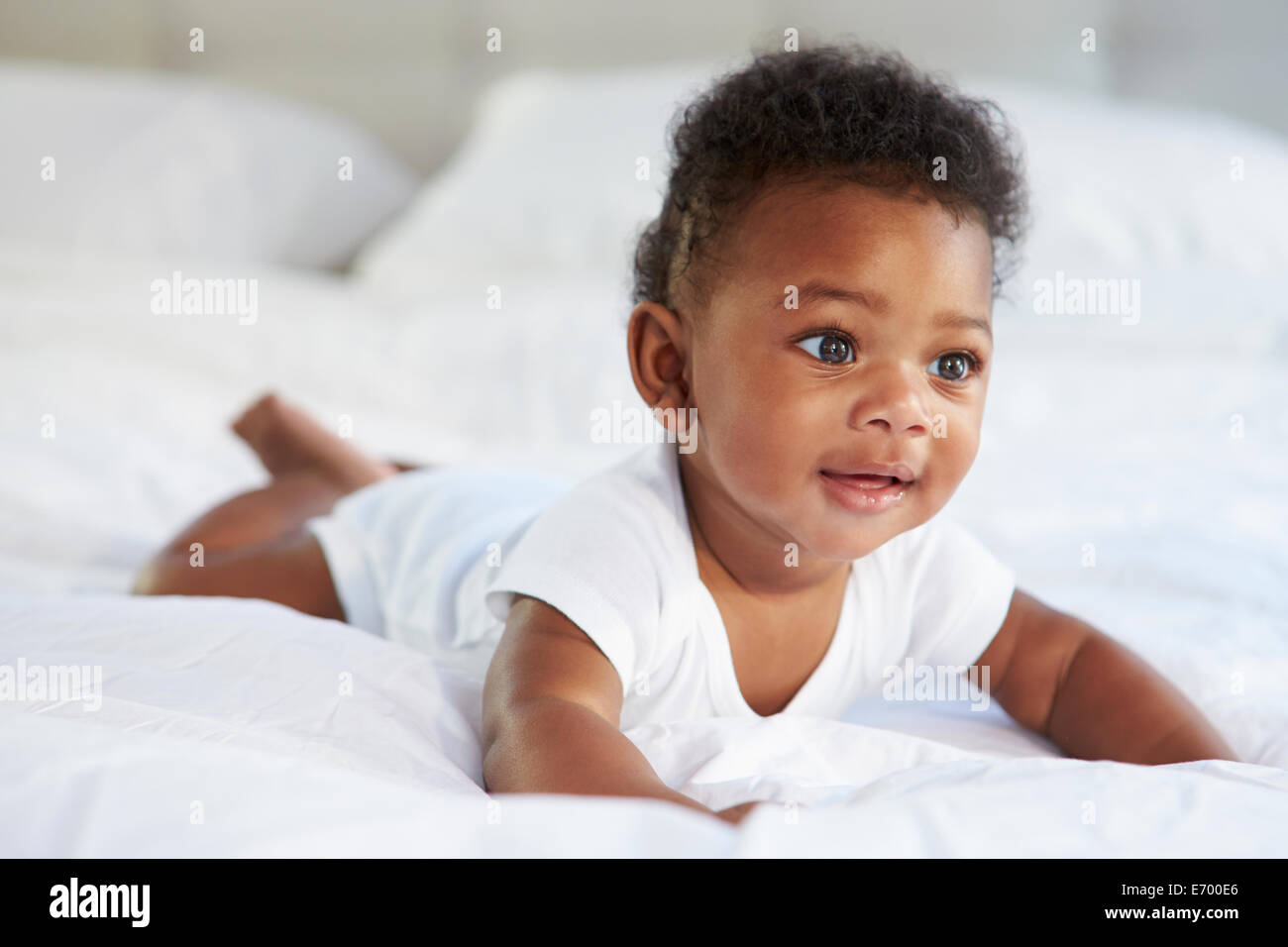 Cute Baby Lying On Tummy In Parent's Bed Stock Photo Alamy
